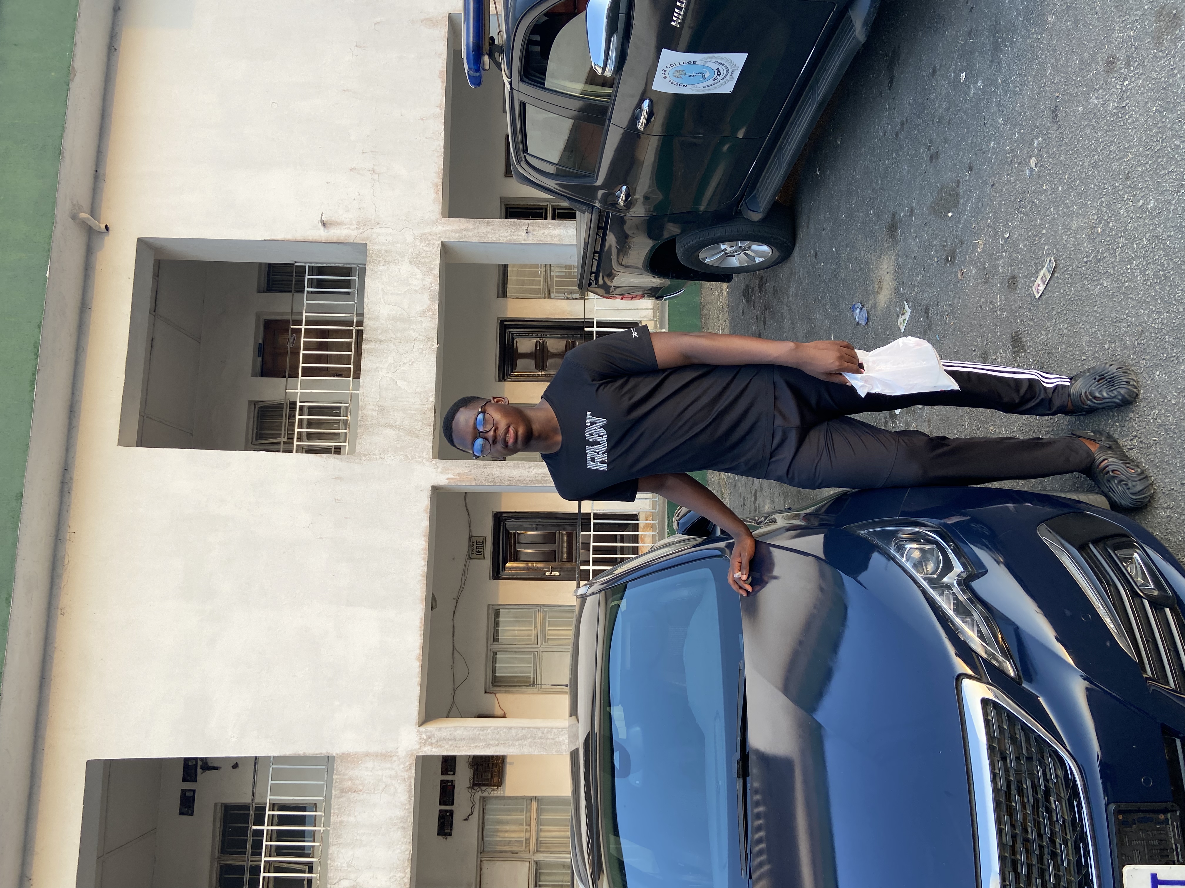 tomi standing beside a car